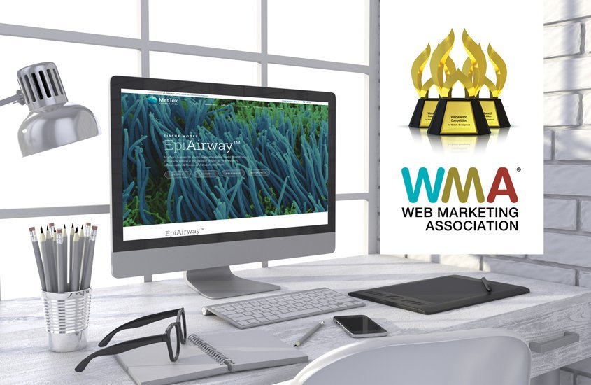 Photo of a desktop computer with the Mattek website and the WMA awards and logo.