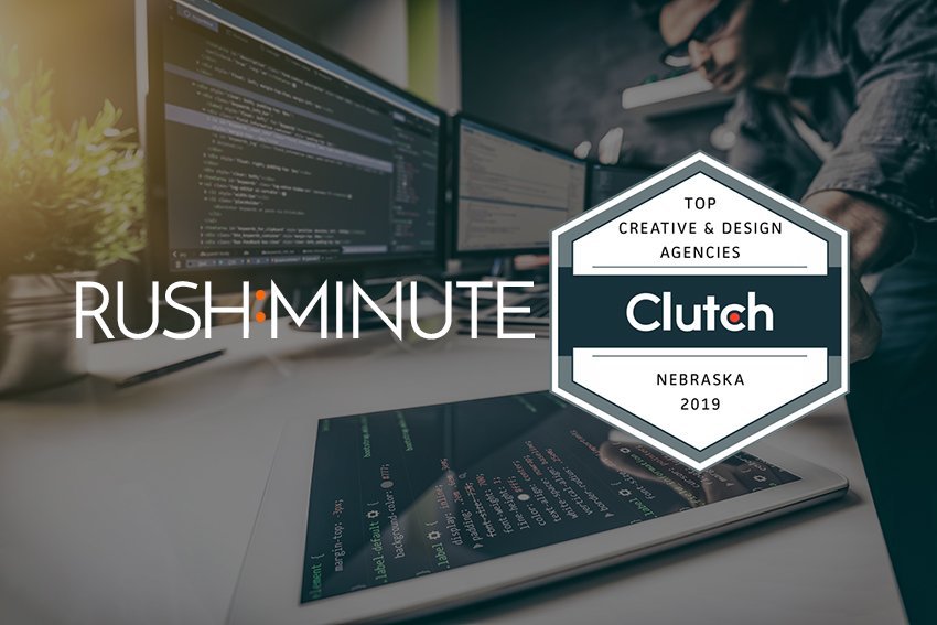Clutch award badge and Rushminute logo over a darkened image of designer in front of computers.
