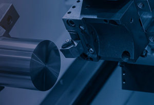 Close up of a CNC lathe in a blue duotone.
