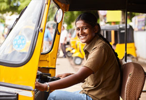 smiling woman driving tuktuk